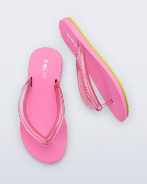 Top and side view a pair of brown Flip Flop Airflow sandal with a clear pink strap and green bottom