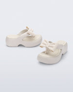 Side and angled view of a pair of beige Free Fuzzy Platform flip flops