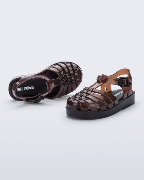 Angled and top view of a pair of clear brown Possession baby sandals