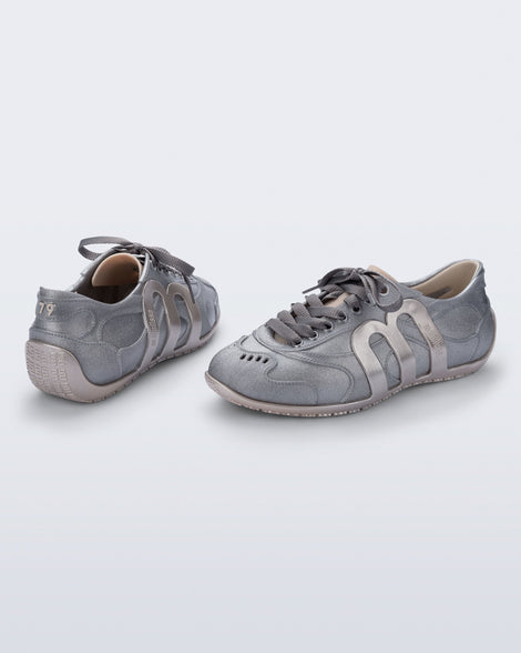 Back and angled view of a pair of silver Motion sneakers with grey laces