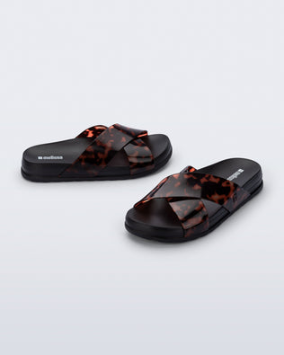 Side and angled view of a pair of black/tortoise Cozy Cross sandals with crisscross top straps