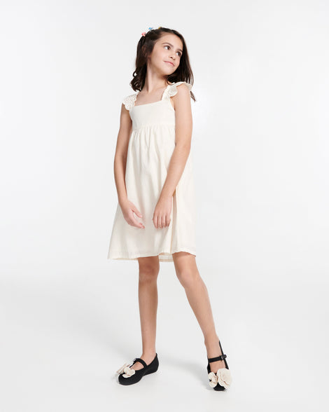 Child model in a white dress wearing a pair of black Soft Ballerina Petals kids flat with beige flowers