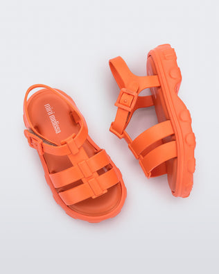 Side and top view of a pair of orange Ella baby sandals