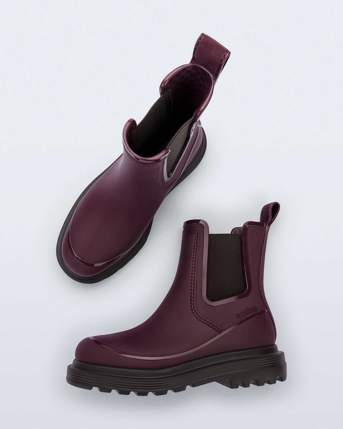 Top and side view of a pair of burgundy Noir Boots with brown soles