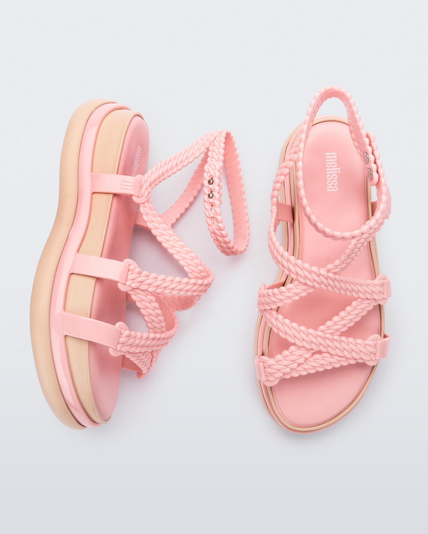 A top and side view of a pair of pink Melissa Buzios platform sandals with multiple textured straps that mimic sisal braids across the front of the shoe as well as an ankle strap