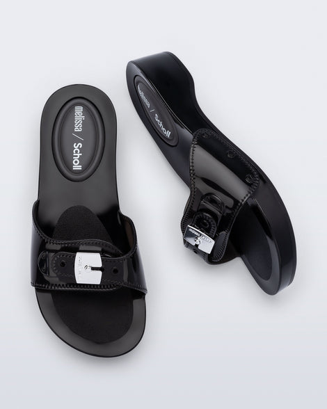 Top and side view of a pair of black Pescura Heel + Scholl slides with top buckle