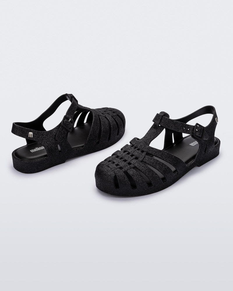 Back and angled view of a pair of glitter black Possession fisherman sandal