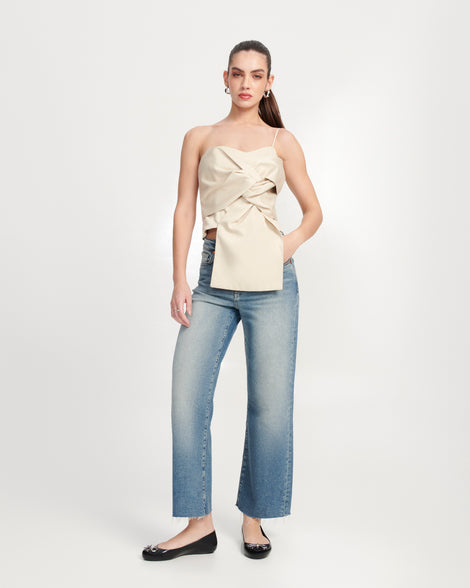 Model in jeans and a beige top wearing a pair of black Sweet Love Chrome flats with silver bow