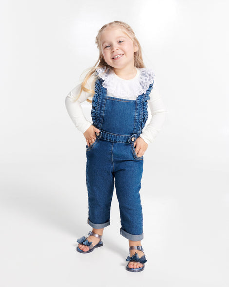Child model in blue overalls top wearing a pair of glitter blue baby Butterfly sandals with butterflies
