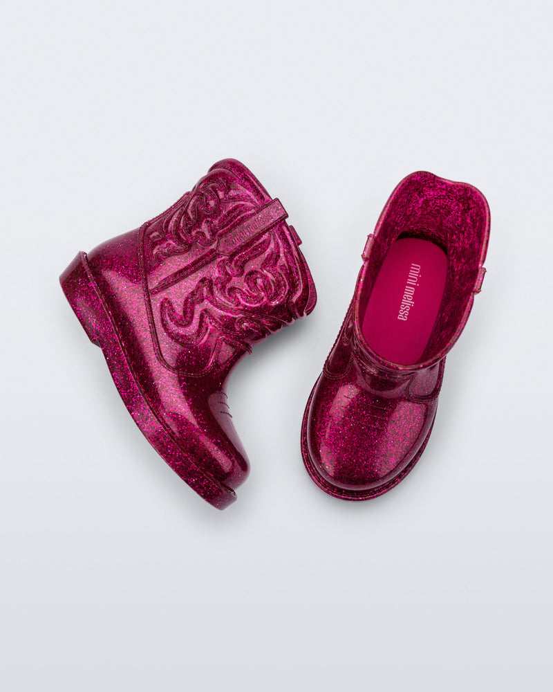 Top and side view of a pair of glitter pink Texas baby boots