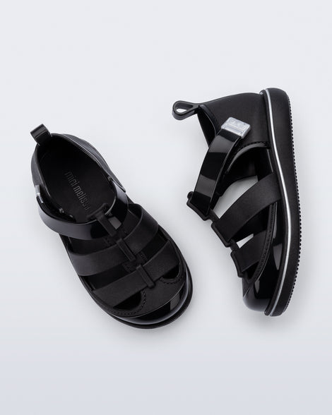Top and side view of a pair of black Smash closed toe baby sandals with grey trim