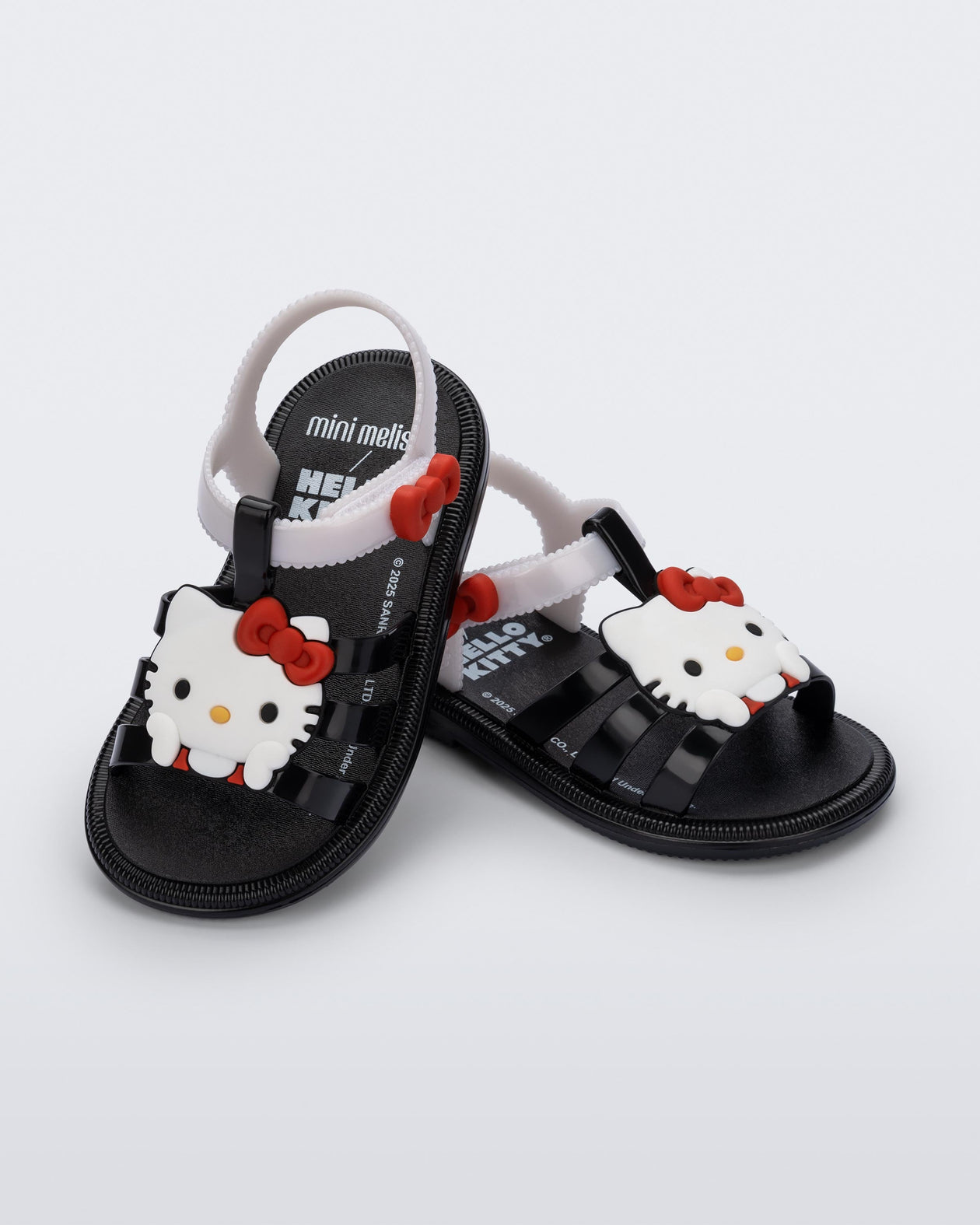 Angled view of a pair of black Hip + Hello Kitty and Friends sandals with white ankle straps and Hello Kitty on upper