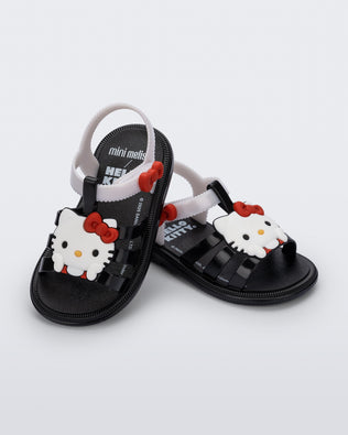 Angled view of a pair of black Hip + Hello Kitty and Friends sandals with white ankle straps and Hello Kitty on upper