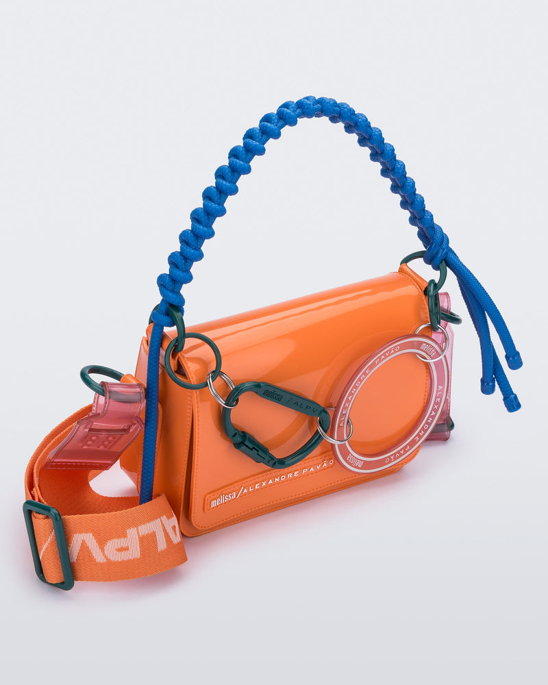 Angled view of an orange Olga Bag + Alexandre Pavao with blue short strap fabric long  strap
