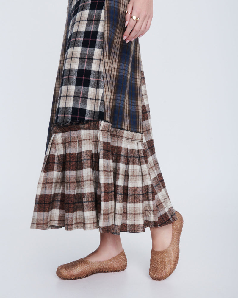 Model's legs in a plaid long skirt wearing a pair of clear beige Campana Papel Hug flats