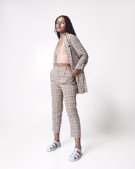 Model in a brown plaid suit wearing a pair of blue Emma women's sandals.