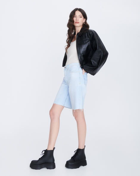 Model in jean shorts white tank and black jacket wearing a pair of matte black Coturno Soft Platform boots