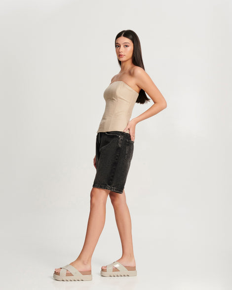 Model in a black skirt and beige corset top wearing a pair of beige/brown Cozy Cross platform sandals with crisscross top straps