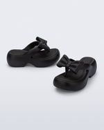 Side and angled view of a pair of black Free Fuzzy Platform flip flops