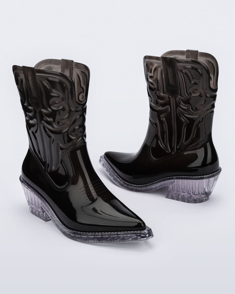 Angled view of a pair of black Texas boots with pointed toe and clear sole.
