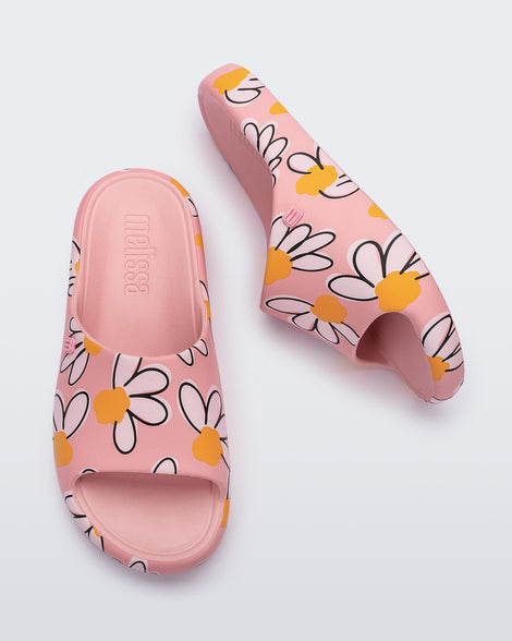 Top and side view of a pair of pink Free Print Slides with daisy print flowers
