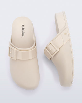 Top and side view of a pair of beige kids Cozy Clogs