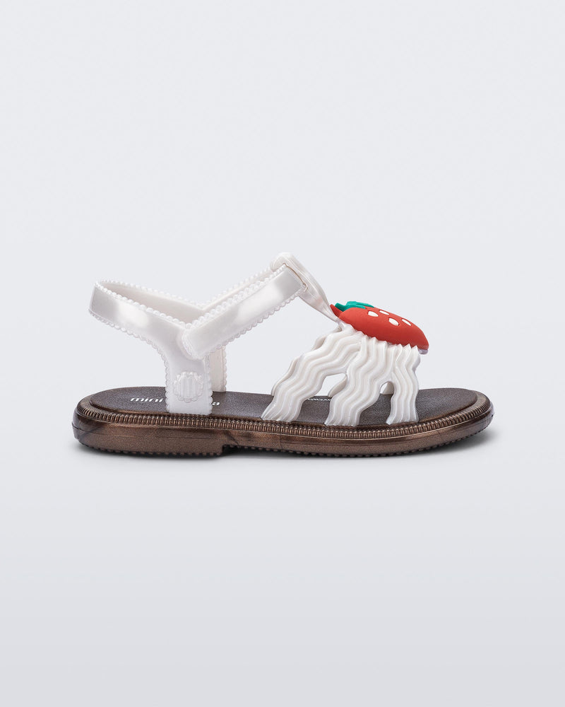 Side view of a pearly white baby Hip Sandal with red strawberry
