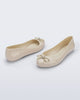 Back and angled view of a pair of beige Sweet Love Chrome flats with gold bow