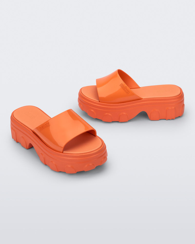 Side and angled view of a pair of orange Ella slide platforms