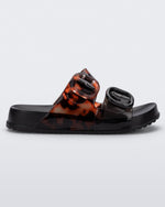Side view of a black tortoiseshell Mini Melissa Cozy slide with two front straps with buckle details