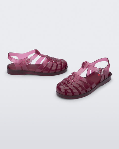 Side and angled view of a pair of clear cranberry Possession fisherman sandals