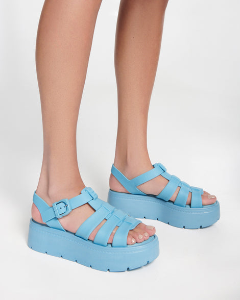 Model's legs wearing a pair of blue Up Platform sandals