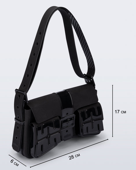 Angled view of a black Cargo bag with two small pockets on the front and an adjustable strap with measurements of the bag: 28cm x 6cm x 17cm