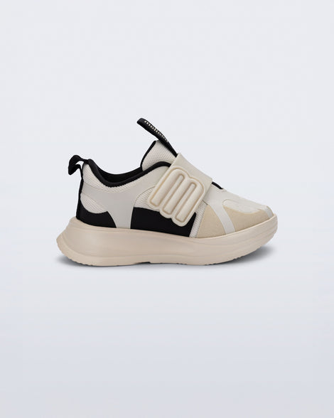 Side view of an off white X Beat baby sneaker with black trim
