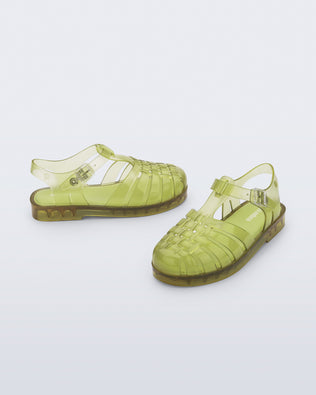 Side and angled view of a pair of transparent green Possession fisherman kids sandals