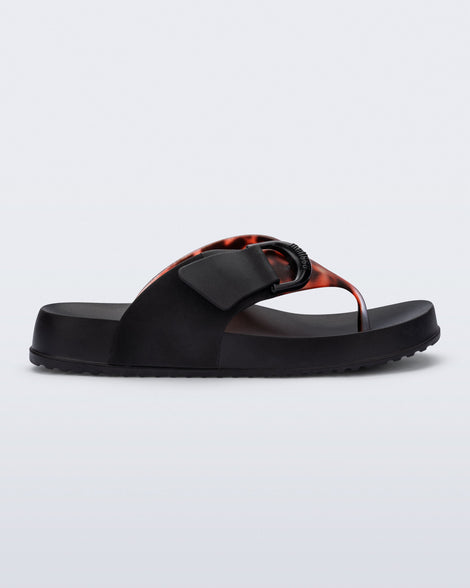side view of a black Cozy Thong Flip flop with brown tortoise strap