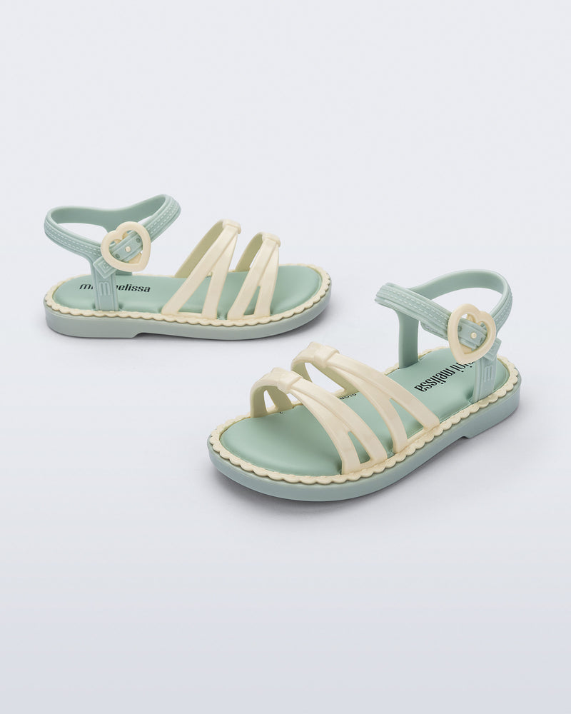 Side and angled view of a pair of green Aurora baby sandals with beige trim, straps and buckle