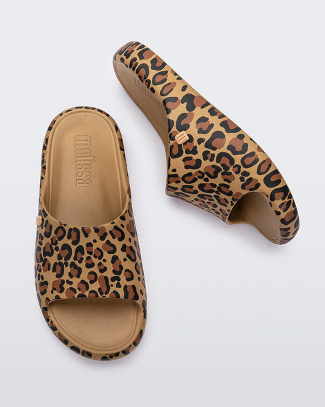 Top and side view of a pair of beige Free Print Slides with leopard print