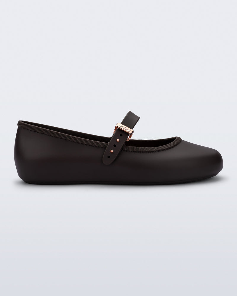 Side view of a brown Soft Ballerina flat with top strap and rose gold buckle
