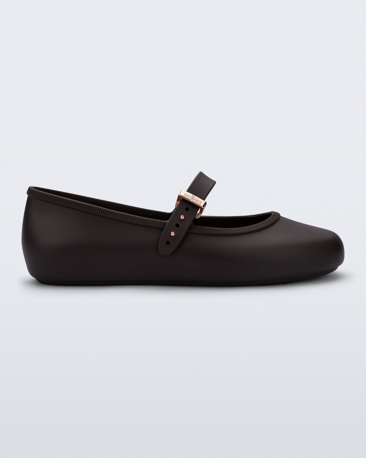 Side view of a brown Soft Ballerina flat with top strap and rose gold buckle