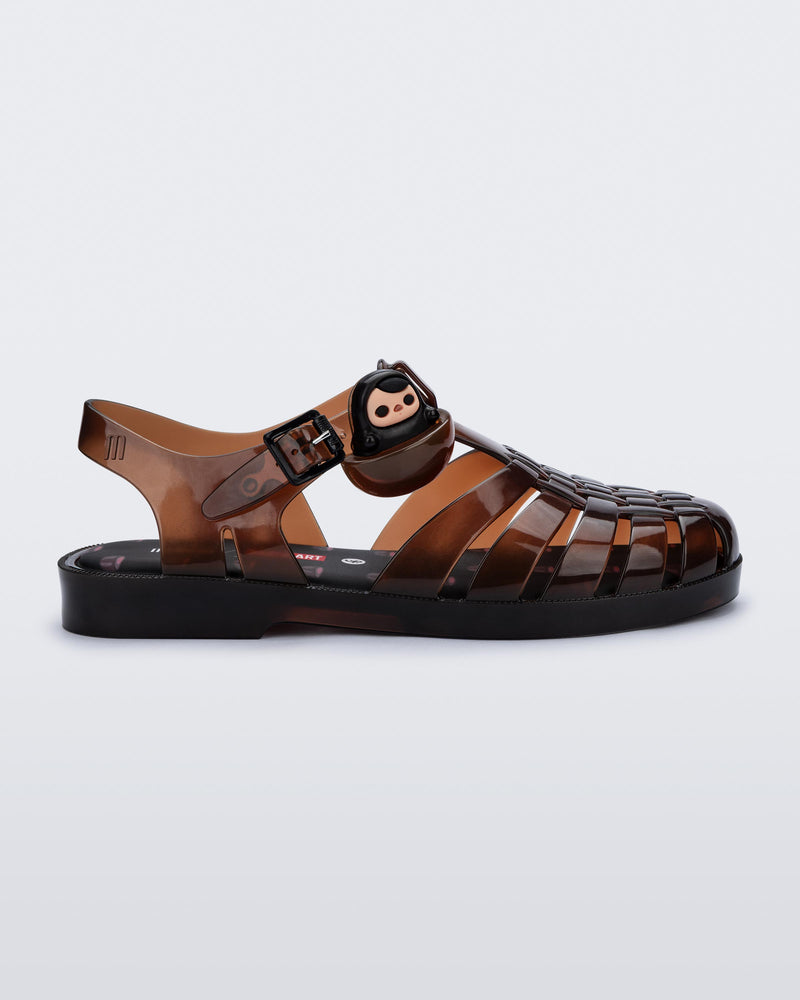 Side view of a clear brown Possession + Pop Mart Pucky fisherman sandal