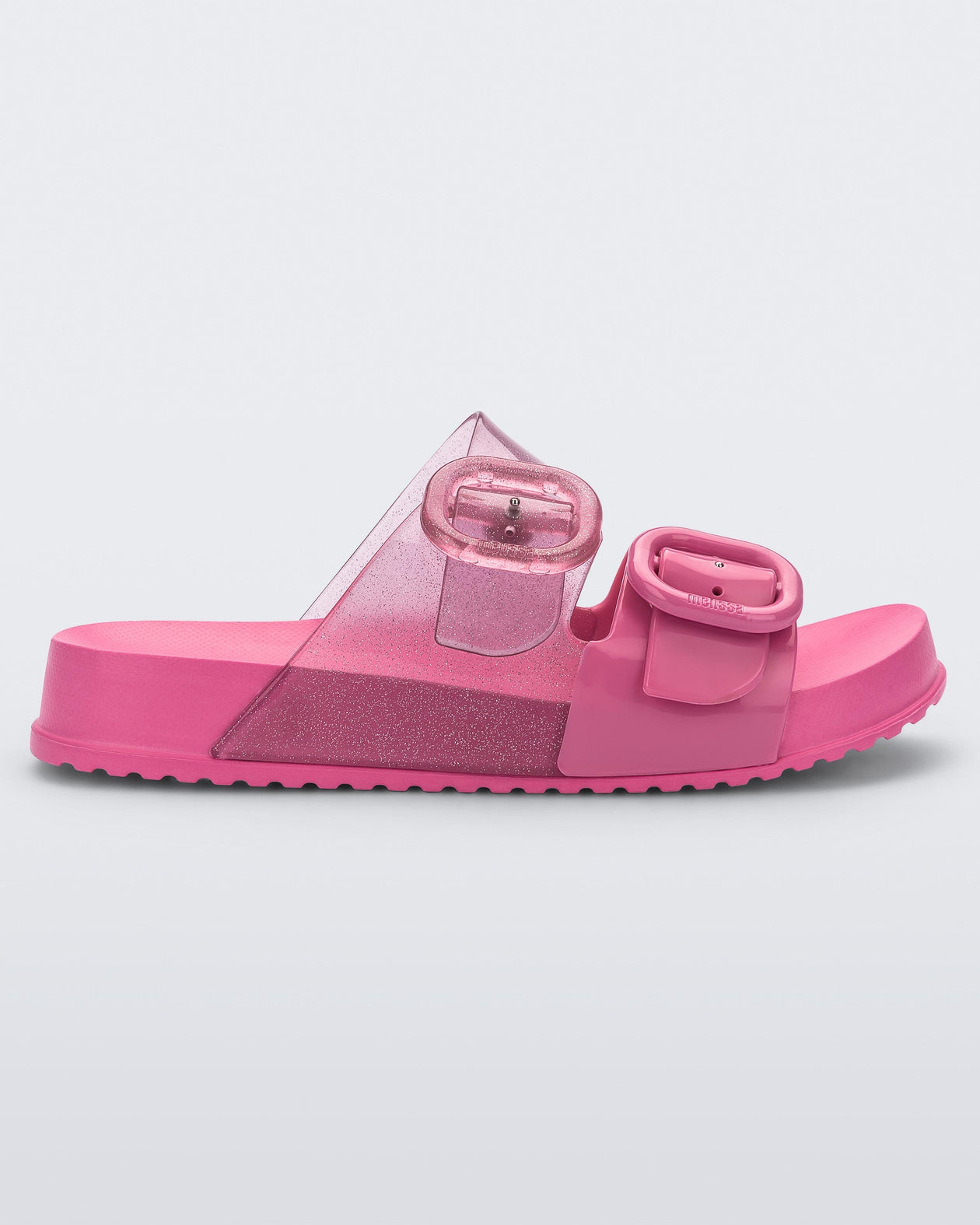 Side view of a pink Mini Melissa Cozy slide with two front straps with buckle details
