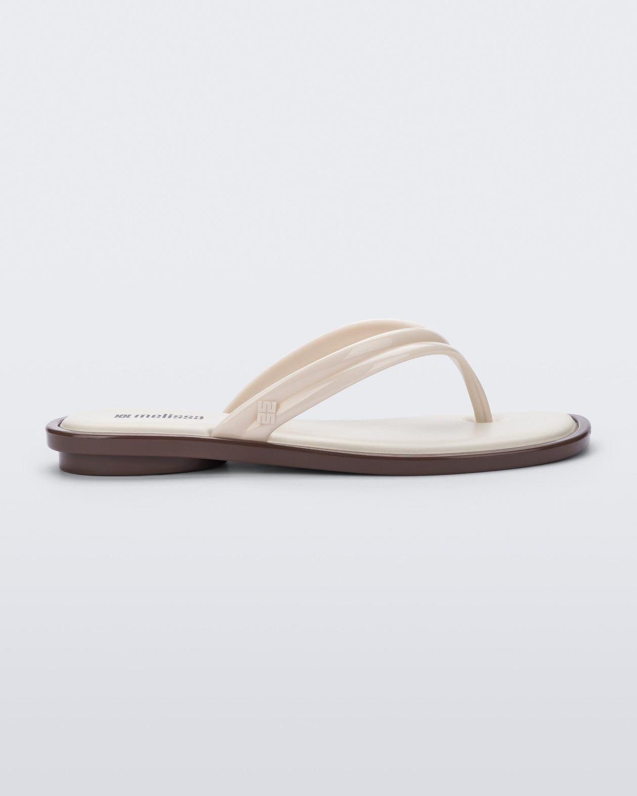 Side view of a beige Wave Flip Flop with small heel and brown sole