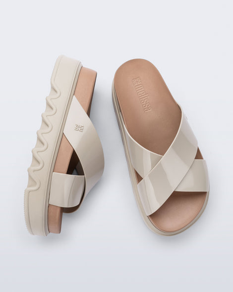 Top and side view of a pair of beige/brown Cozy Cross platform sandals with crisscross top straps