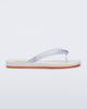 Side view of a white Flip Flop Airflow sandal with a clear strap and orange bottom