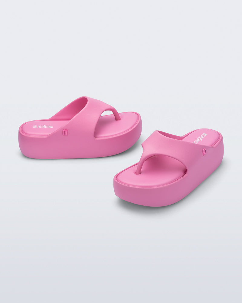 Side and angled view of a pair of pink Free Platform Thong sandals