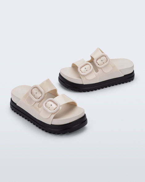 Side and angled view of a pair of beige Cozy Platform kids slides with two straps and black sole