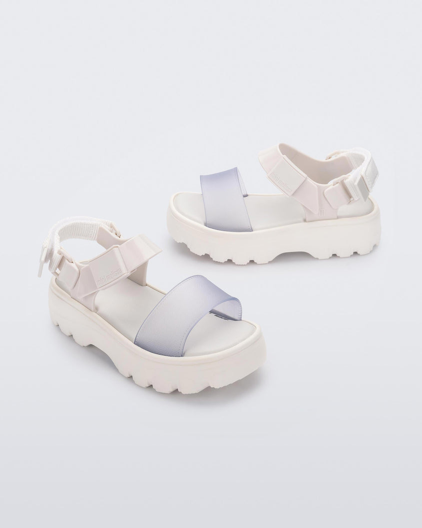 Angled view of a pair of Mini Melissa Kick Off platform sandals in white with adjustable velcro ankle straps 