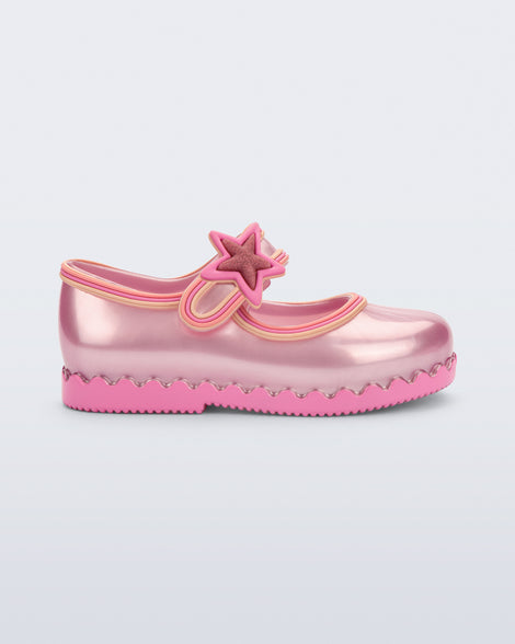 Side view of a  pearly pink Hip Ballerina Star baby flat with star on upper strap