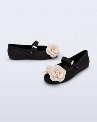 Angled and side view of a pair of black Soft Ballerina Petals flats with beige flowers